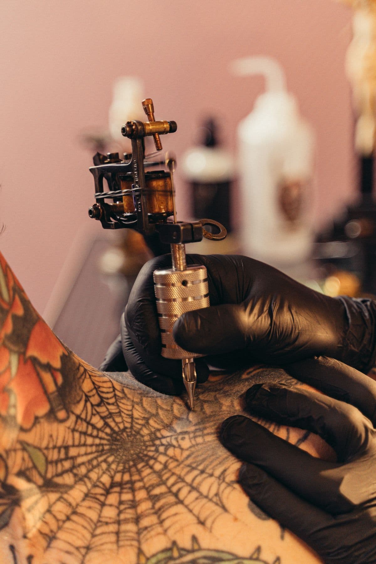 Spiderweb on the chest being tattooed with a coil machine